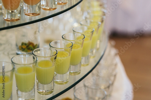 Shots with green alcohol stand on the tired glass dish photo