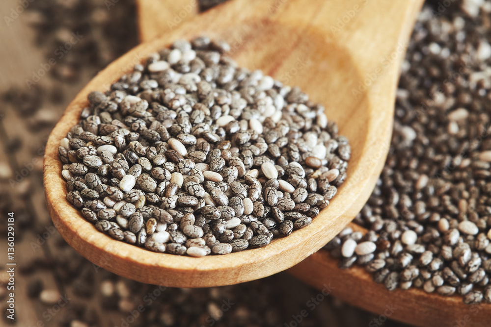 Chia seeds in wooden bowl on rustic background. Copy space
