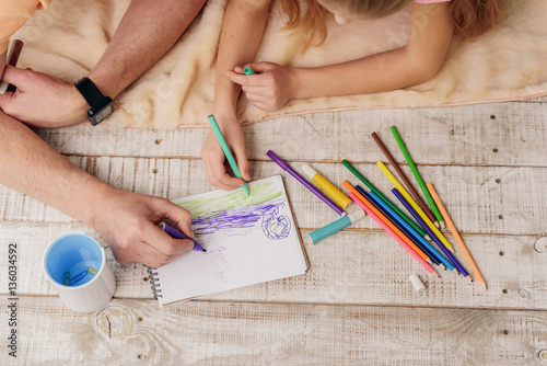 Cheerful grandparent and girl drawing picture together