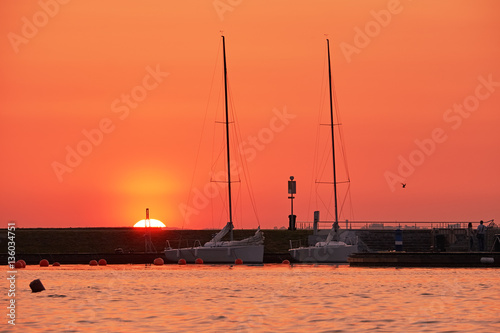 Sailing sunset is a silhouette of a sailboat with a white burnin photo