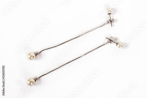 Women's silver earrings with pearls are isolated on a white background