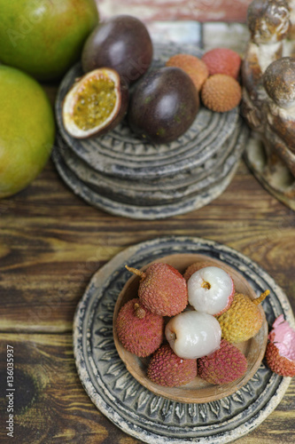Lychees and Passion Fruit or Maracuya and Mango on wooden background
