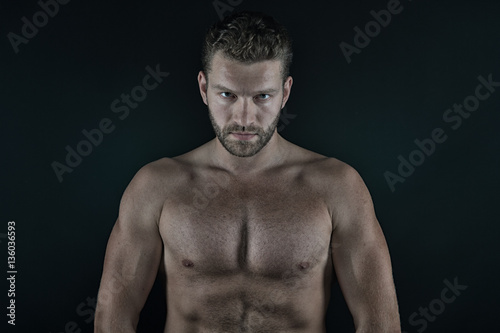 handsome sexy man with muscular body and serious unshaven face
