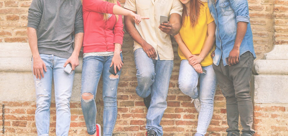 Multi ethnic friends watching videos on mobile phones Multi ethnic friends watching videos on mobile phones