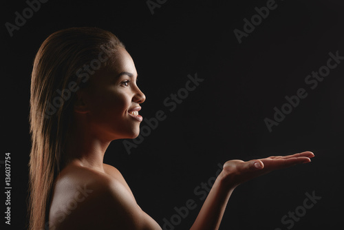 Happy african woman presenting something