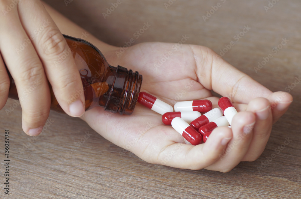 capsule and bottle on palm hand