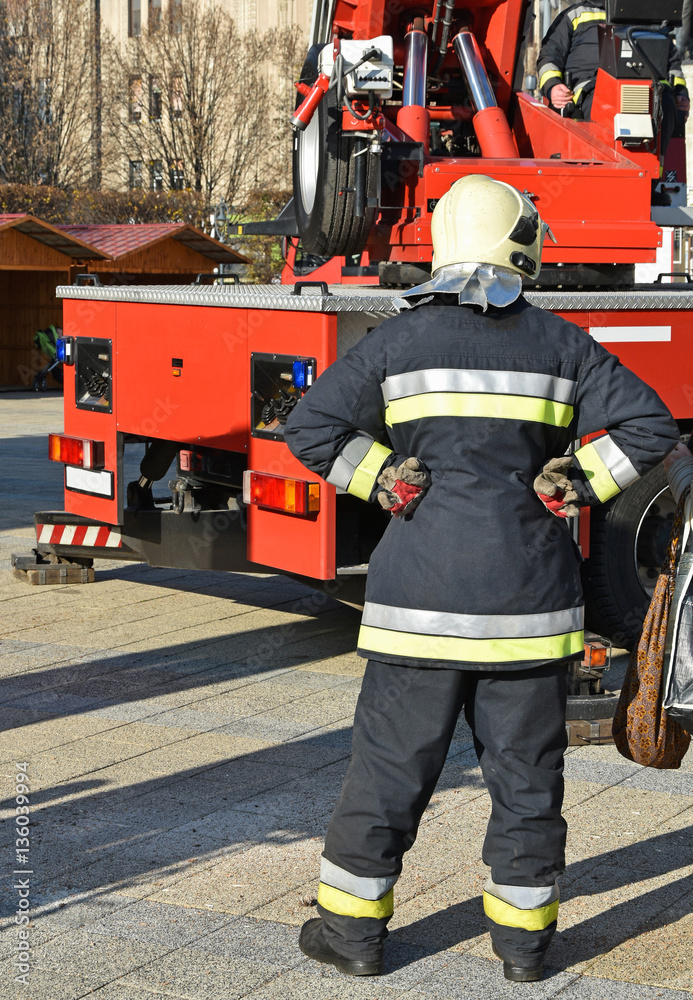 Firefighter stands next to a crane Firefighter stands next to a crane