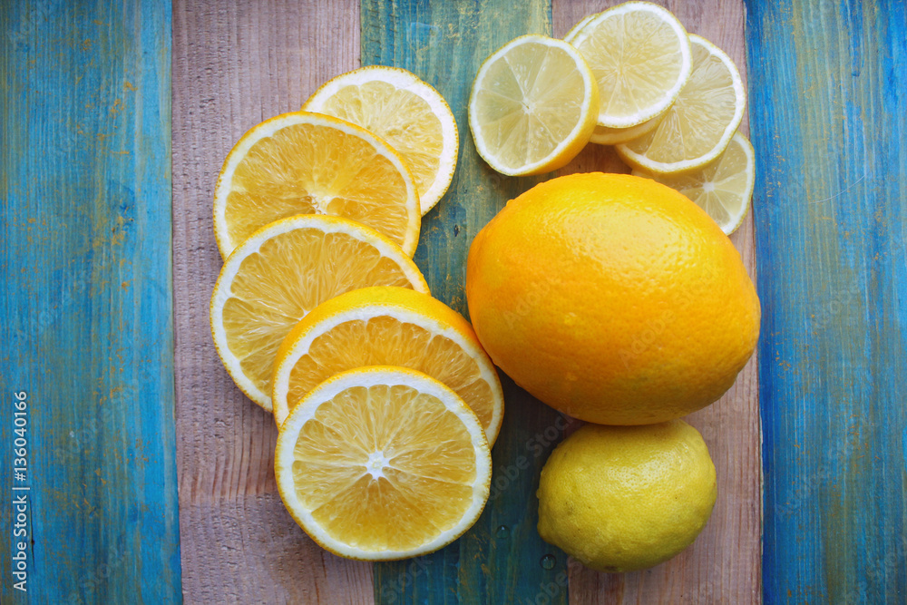 slices of lemon and orange on a wooden table slices of lemon and orange on a wooden table