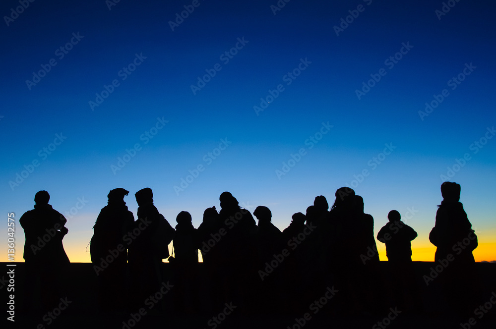 First sunrays at the skyline and silhouette people First sunrays at the skyline and silhouette people