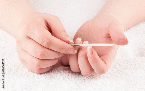 Woman using nailfile during making menicure herself photo
