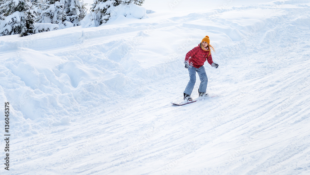 girl goes on a snowboard at the ski slopes