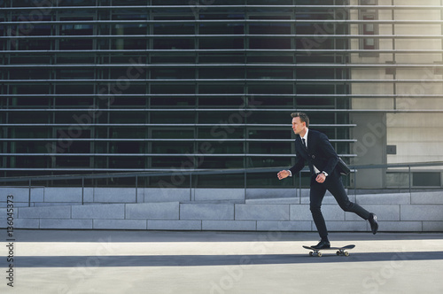 Businessman pushing his skateboard with purpose