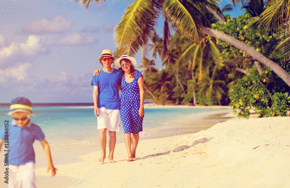 happy family with child walking on tropical beach