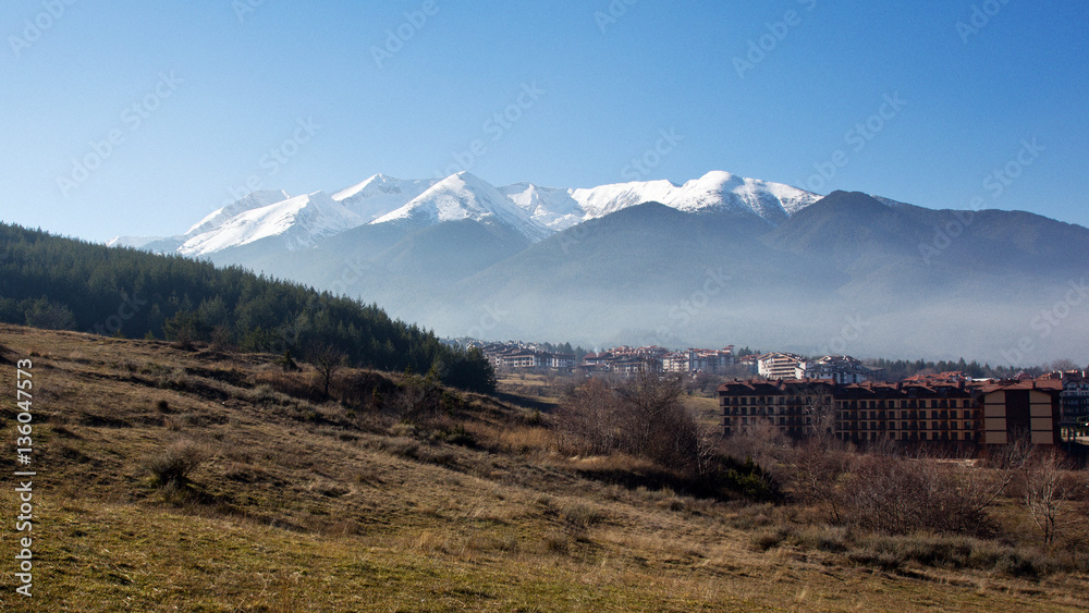 Fototapeta premium Snow peaks over the Bansko town, Razlog, Bulgaria