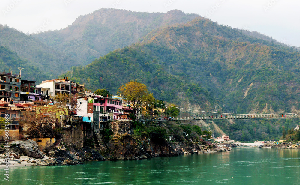 RISHIKESH, INDIA - view to Ganga river, lakshman jhula bridge and colored houses