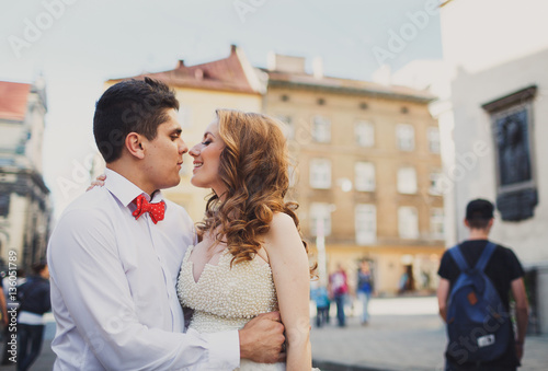 The lovely couple in love embracing in the center of town