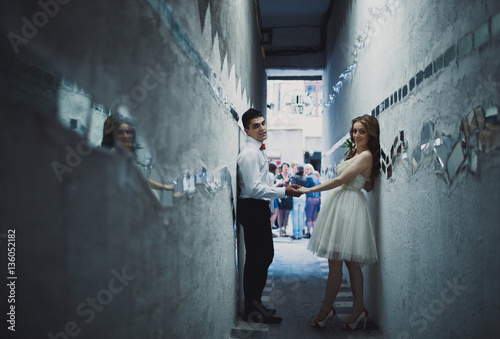 The beautiful couple in love holds hands between walls