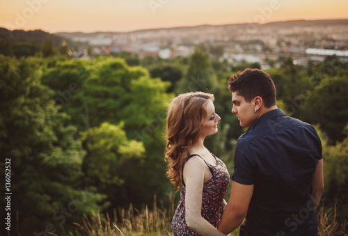 The lovely couple in love embracing on the field