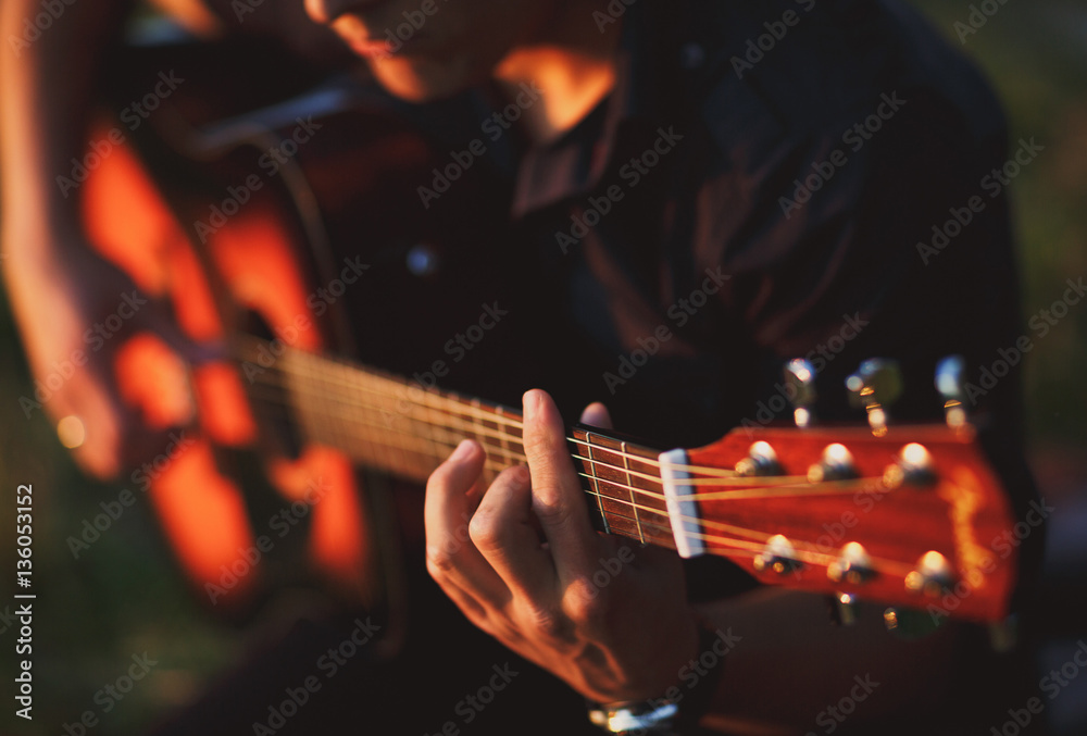 Fototapeta premium The boy plays on guitar