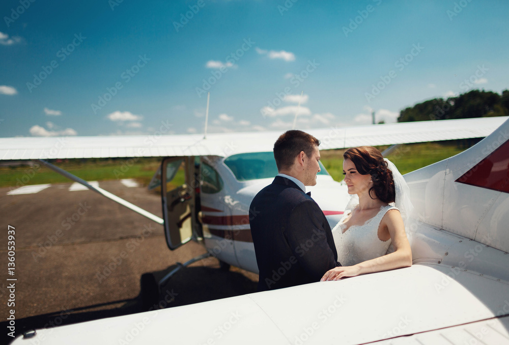 beautiful and young newlyweds standing near helicopter