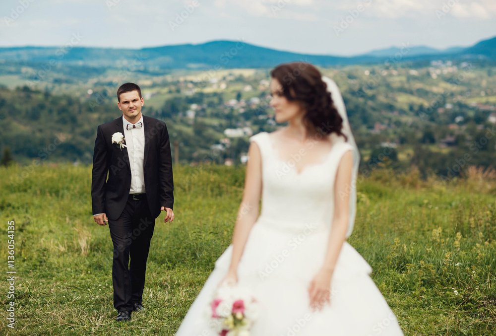beautiful and young bride and groom standing together outdoors