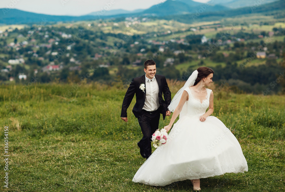 beautiful and young bride and groom walking outdoors