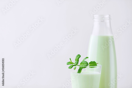 Milk cocktail with mint on a rustic white table