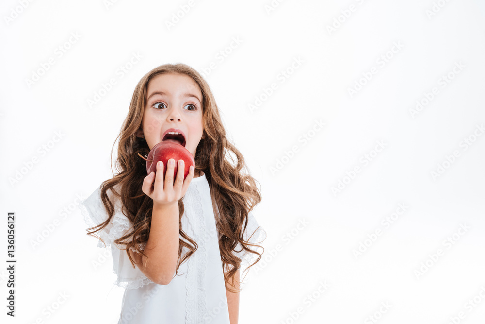 Cute little girl holding and eating red apple Cute little girl holding and eating red apple