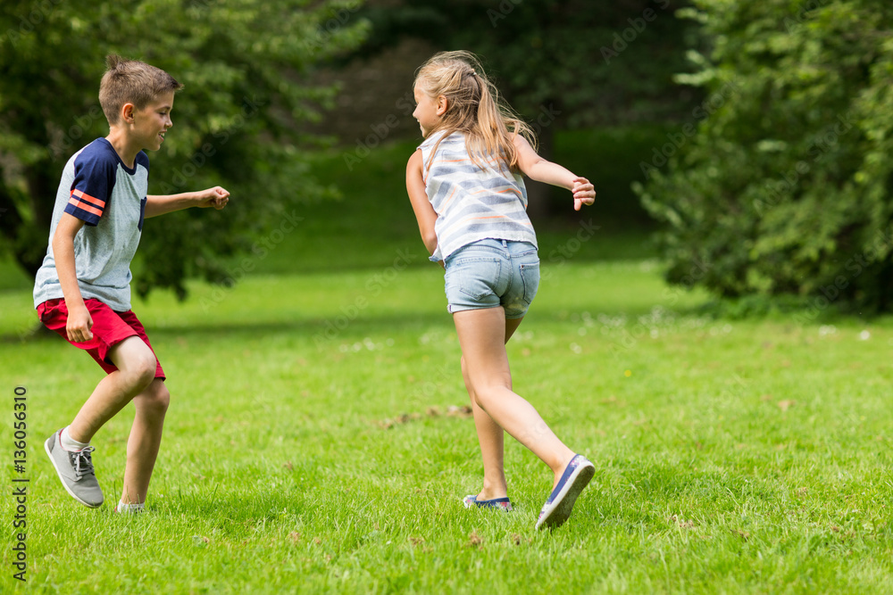 group of happy kids or friends playing outdoors