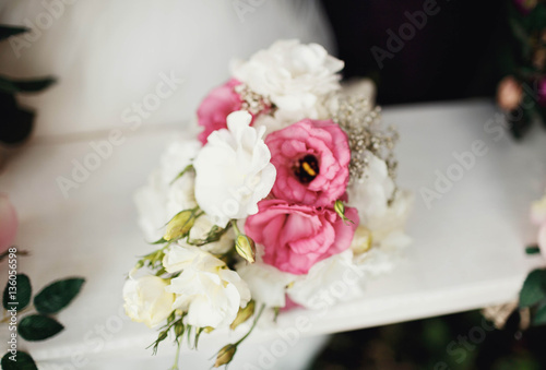 beautiful wedding bouquet of flowers lying on white surface