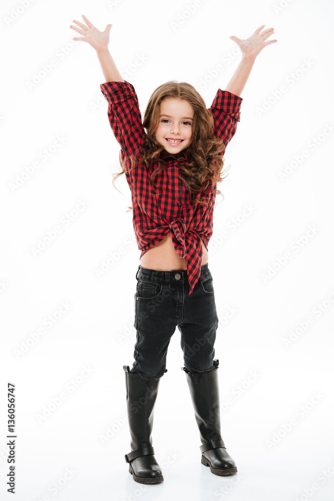 Full length of cheerful little girl standing with raised hands
