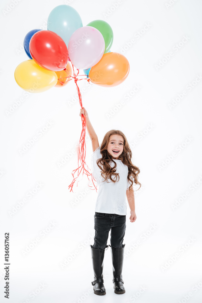 Full length of little girl standing and holding colorful balloons Full length of little girl standing and holding colorful balloons