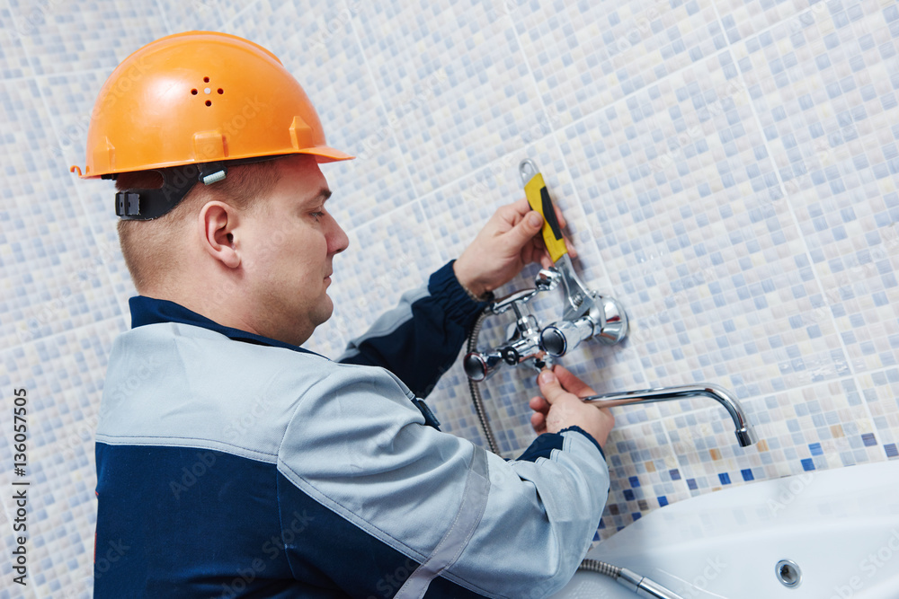 Fototapeta premium Plumber service. worker installing mixer tap