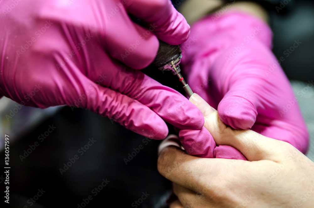 Adjusting the length of the nail with a router after applying the gel polish.