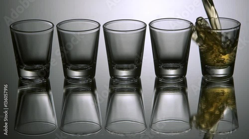 Pouring tequila shots, slow motion.