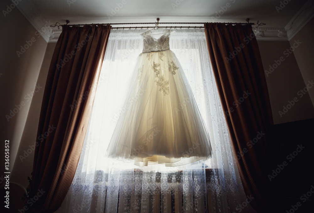 The wedding dress hangs on the hanger The wedding dress hangs on the hanger