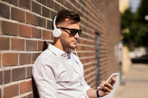 man with headphones and smartphone listening music