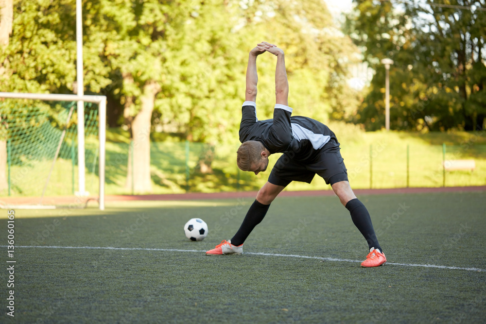 soccer player stretching leg on field football