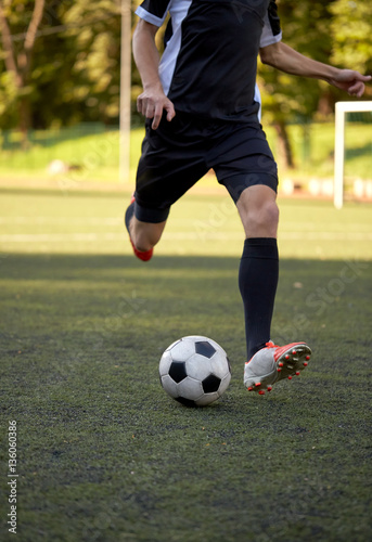 soccer player playing with ball on football field