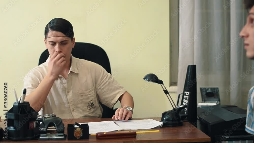 Film director in hair net angry talking with office visitor over screenplay, medium shot Film director in hair net angry talking with office visitor over screenplay, medium shot