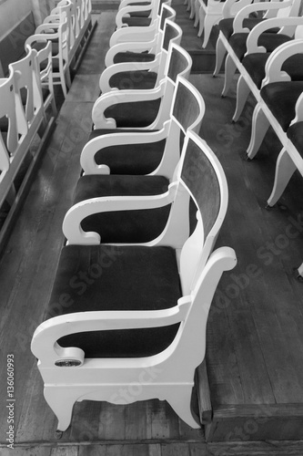 Rows of old chairs in auditorium. Black and white photo