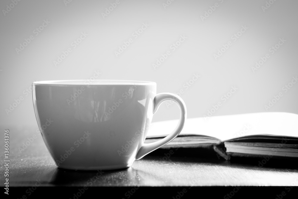 Cup of coffee and book on wooden table Cup of coffee and book on wooden table