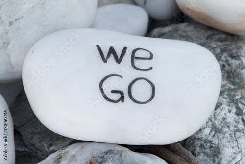 White stone with writing WE GO. Travel concept photo