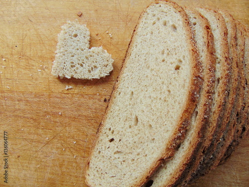 Heart shaped piece of bread in front of full bread photo