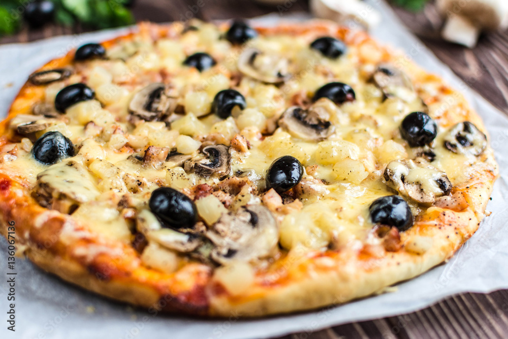 Pizza with meat, mushrooms, pineapple and olives on a wooden background Pizza with meat, mushrooms, pineapple and olives on a wooden background