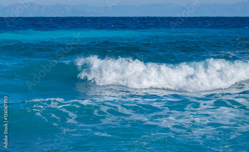 Tableau sur toile A wave breaks on the beach in the Aegean Sea on the island of Rhodes