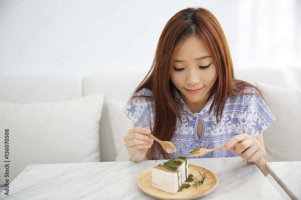 Young Asian Woman eating Green tea crape cake sweet food