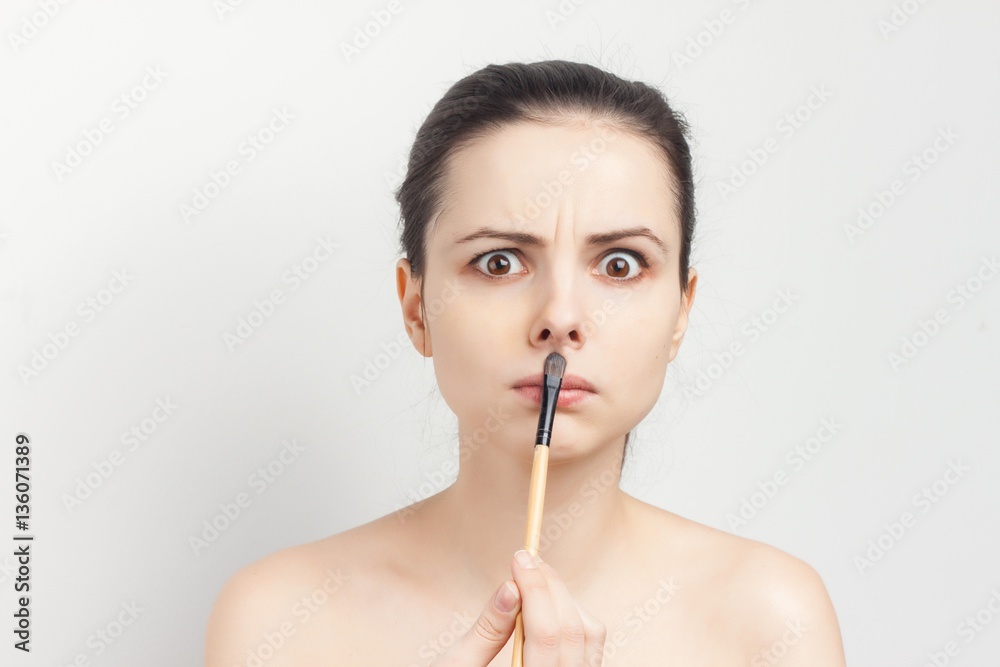 a puzzled woman put a brush to her lips a puzzled woman put a brush to her lips