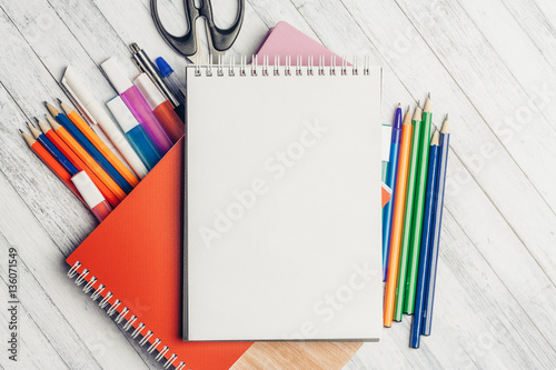 notebook and pencils with pens on the table