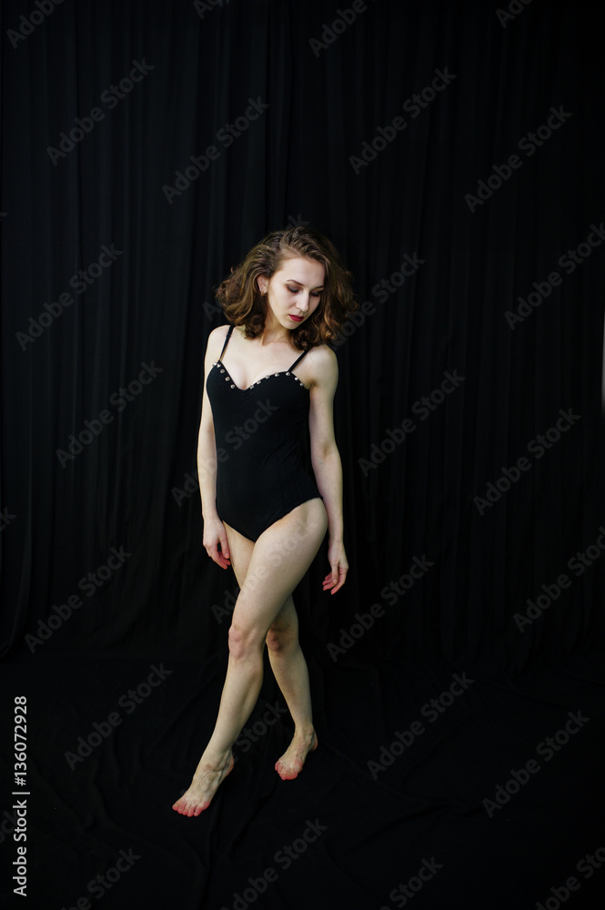 Girl dancer jumping and dancing on a black background. Studio sh